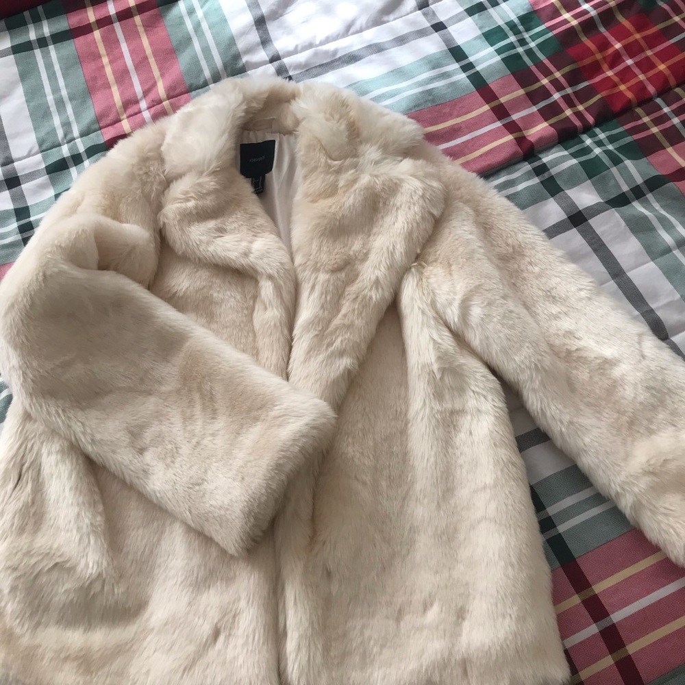 A faux fur coat ,a single snap button-front closure, and long sleeves.